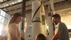 A family stands in front of a rocket in the museum