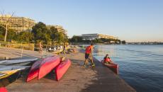 A person helps a kayaker into a red kayak on the waterfront of the Georgetown neighbourhood in Washington, DC